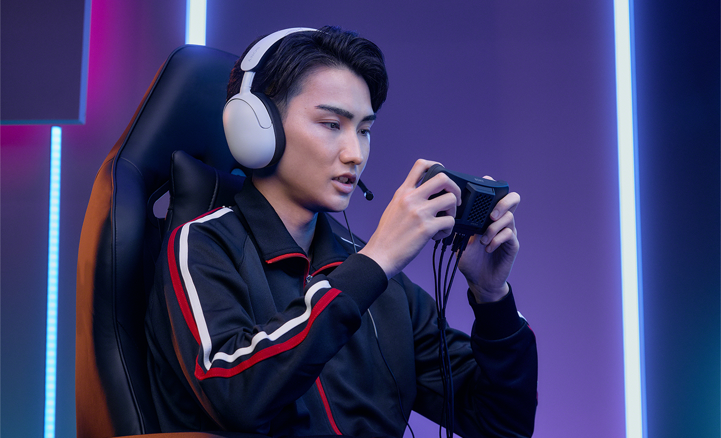 Pro gamer wearing a headset, concentrating hard as he plays on the Xperia 1 IV Gaming Edition